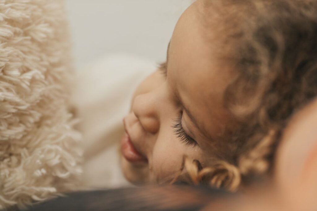 Close-up of a sleeping child cuddling a soft teddy bear, conveying warmth and tranquility.
